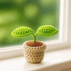 Crochet sprout plant pot on windowsill with garden view