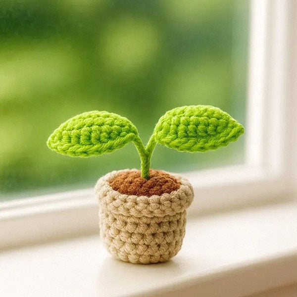 Crochet sprout plant pot on windowsill with garden view