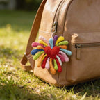 Crochet firework flower keychain on brown leather backpack