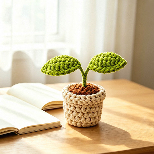 Crochet sprout plant pot on wooden desk with book