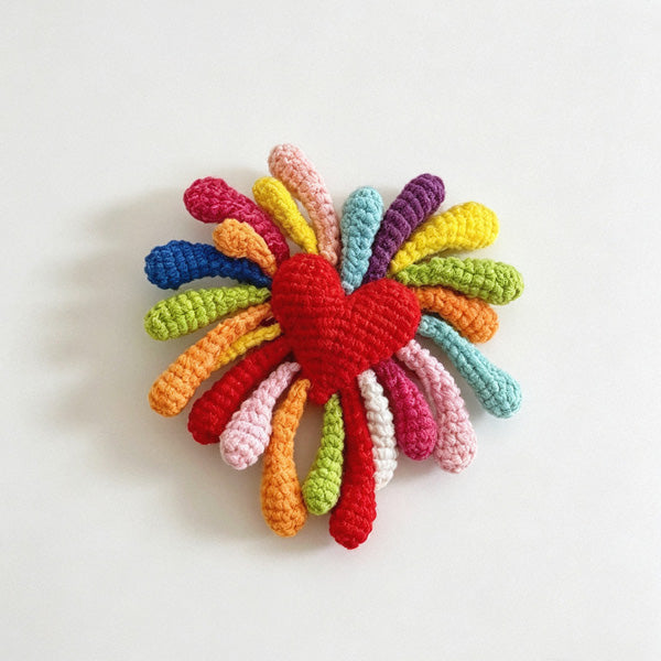 Crochet firework flower keychain on white background close-up