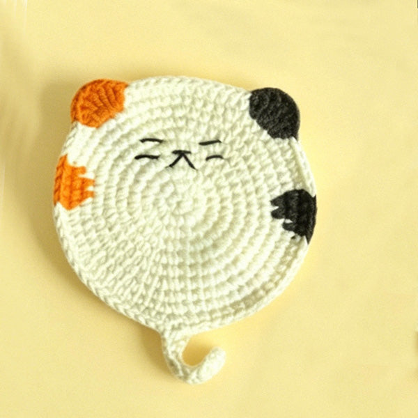 Crochet calico cat coaster in white, styled on table | Knoblom