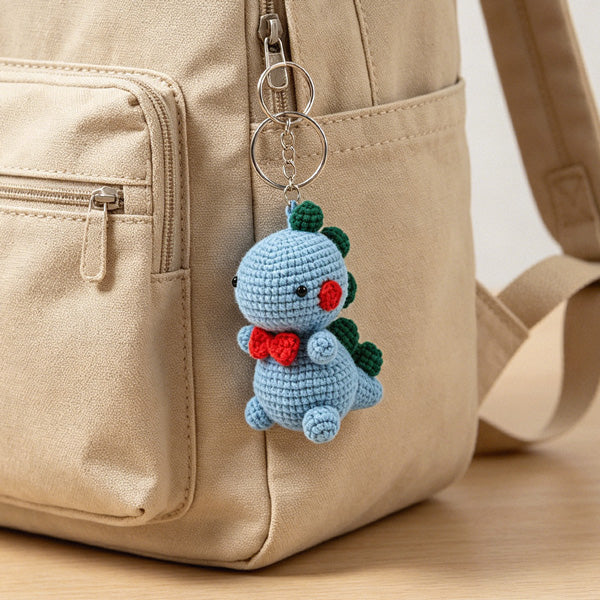 Crochet dino with red bow tie and rosy cheeks, desk version | Knoblom