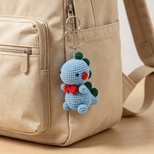 Crochet dino with red bow tie and rosy cheeks, desk version | Knoblom