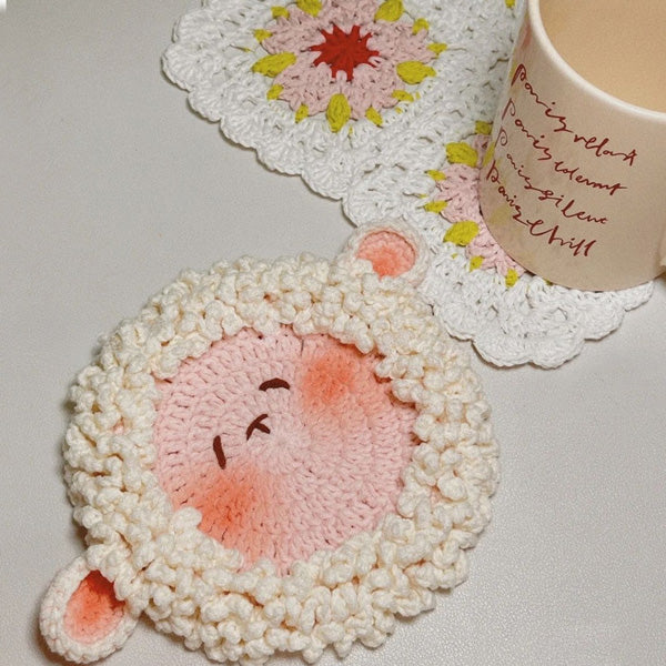 Crochet lamb coaster with rosy pink cheeks, top view | Knoblom