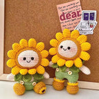 Crochet sunflower dolls standing upright in front of cork board