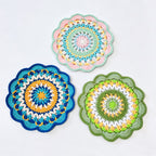 Handmade crochet blue and orange mandala coaster on blue background
