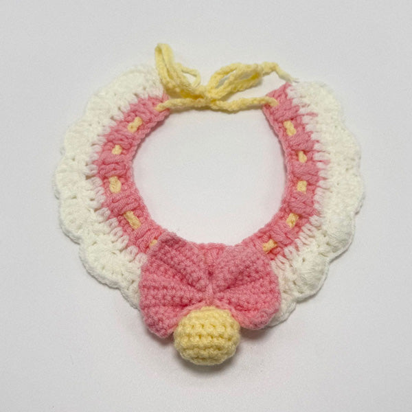 Handmade crochet blue and pink lace ruffle pet collar with bow and yellow pom-pom, flat lay | Knoblom