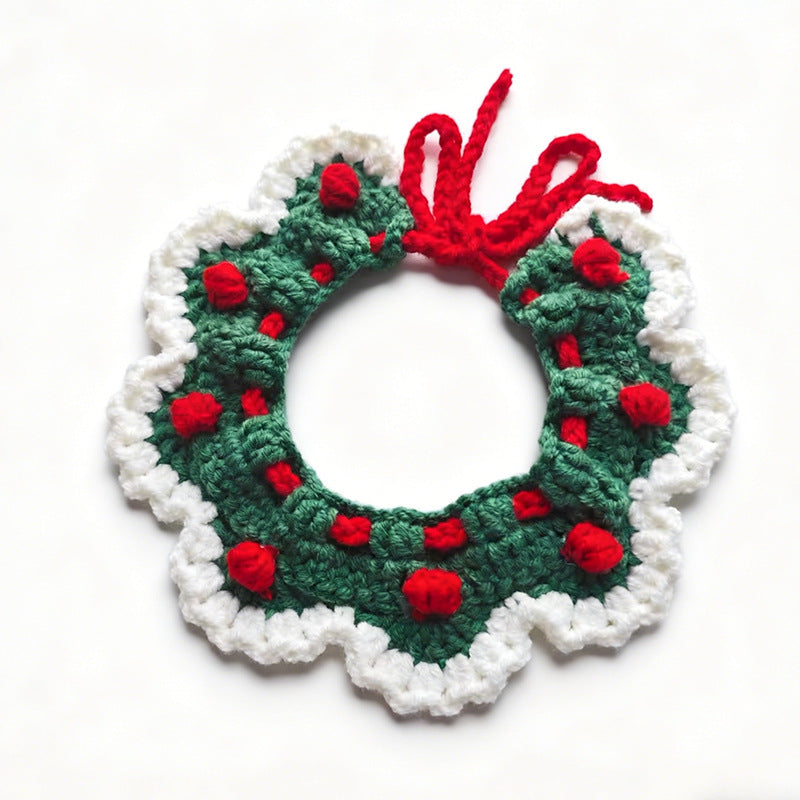 Handmade crochet pet collar in Christmas green with red pom-poms and red bow, flat lay \| Knoblom